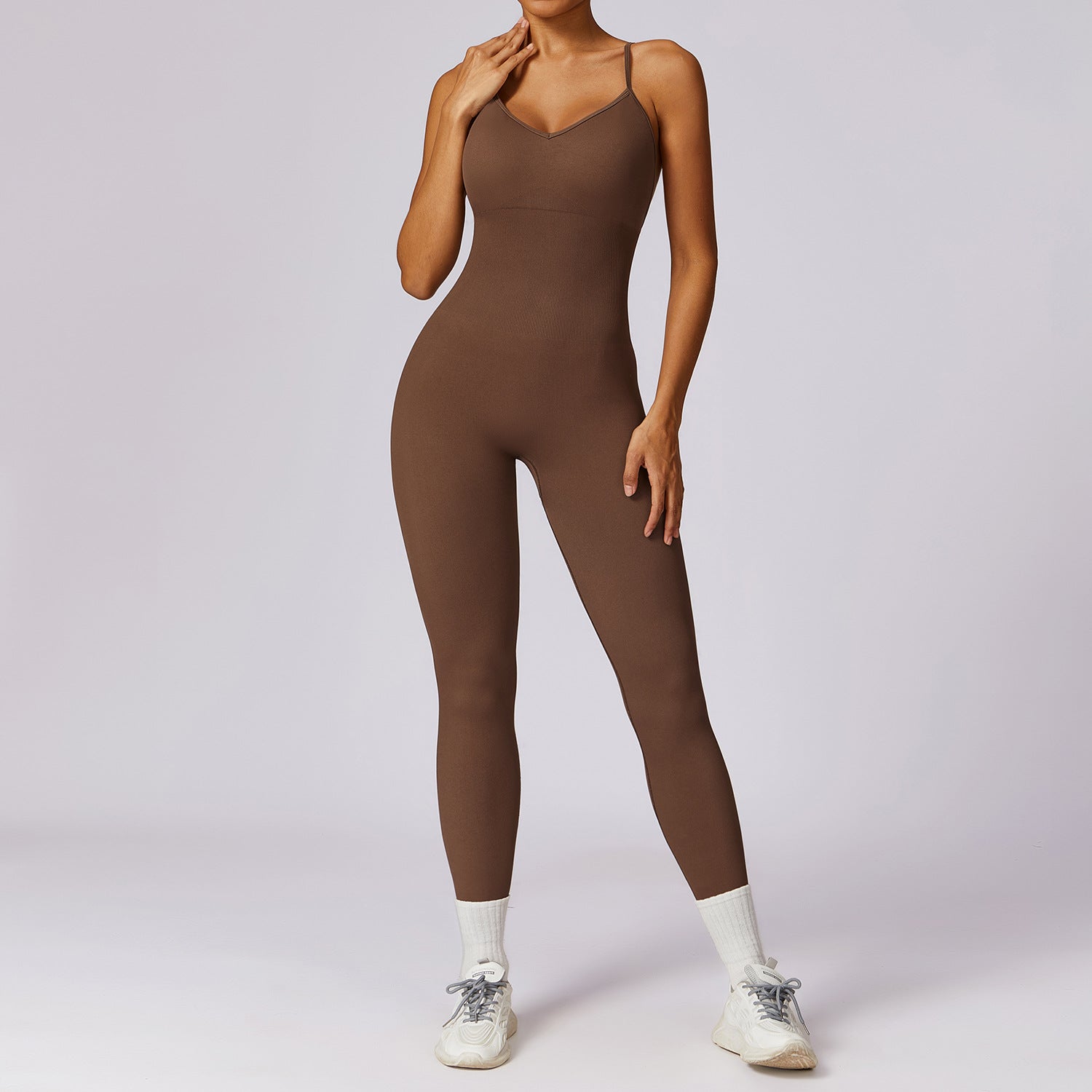 Brown jumpsuit worn by a model on a light gray background