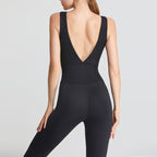 Black jumpsuit with open back worn by a model on a light gray background