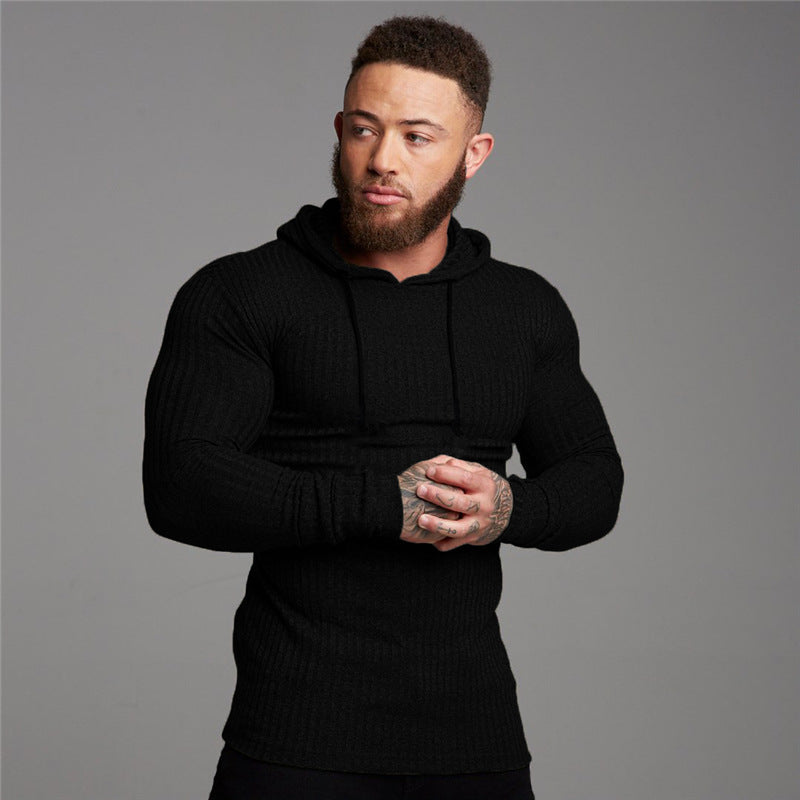 Man wearing a black hoodie against a gray background