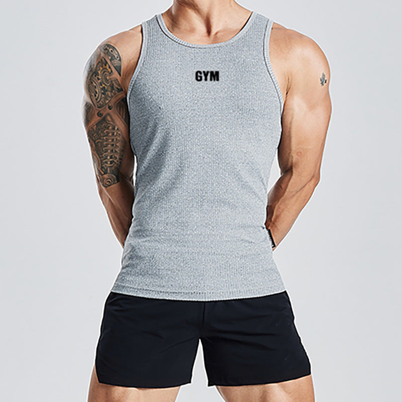 Person wearing a gray tank top with 'GYM' text and black shorts on a light gray background
