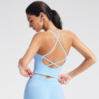 Woman wearing a light blue strappy top and shorts on a plain background