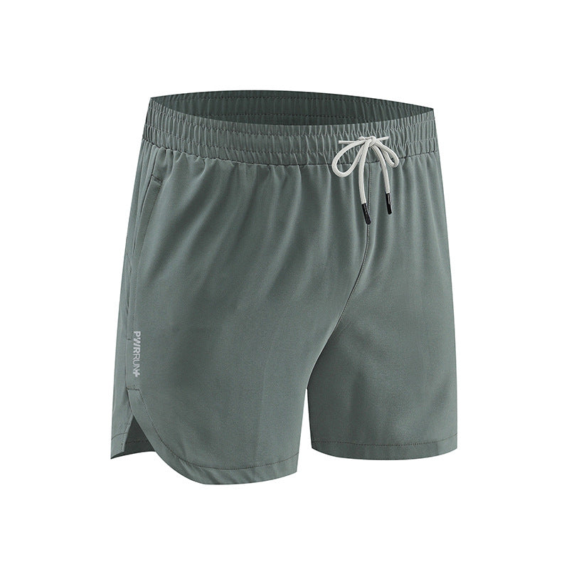 Green athletic shorts with a drawstring on a white background