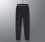 Black pants on a hanger against a gray background