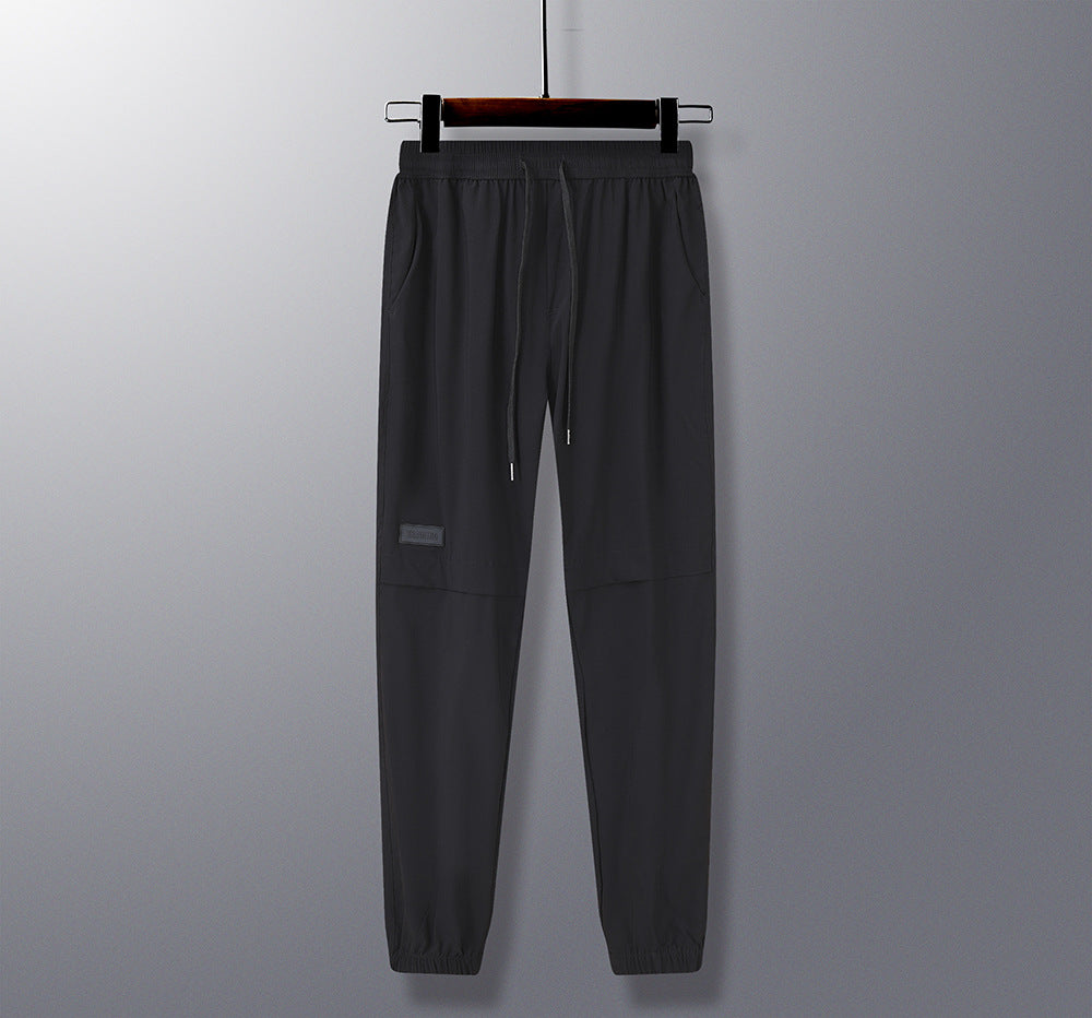 Black pants on a hanger against a gray background