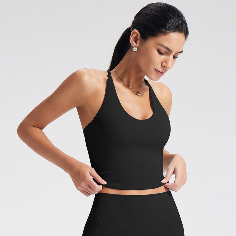 Woman wearing a black sports bra and leggings on a light gray background