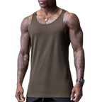 Man wearing a brown tank top with tattoos on arms against a white background