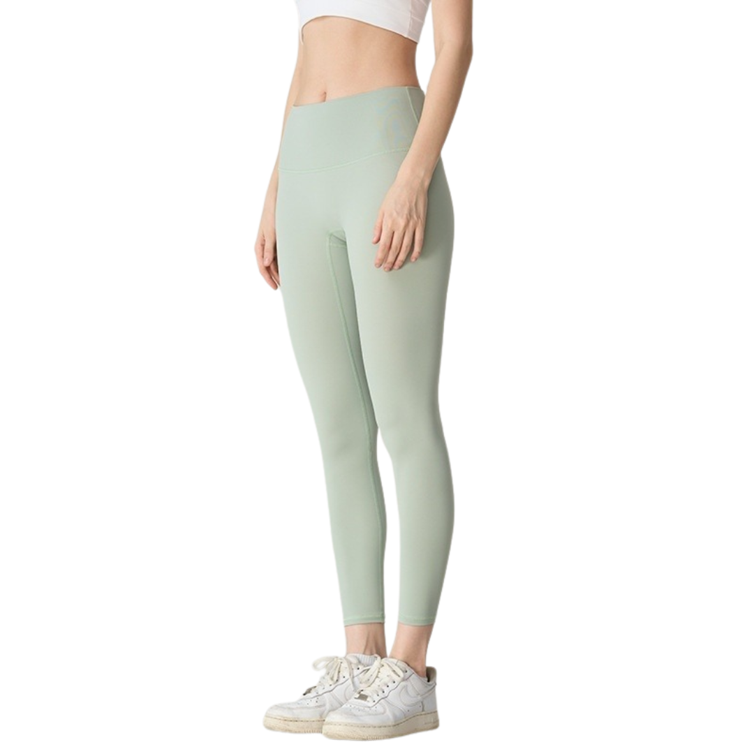 Person wearing light green leggings on a white background