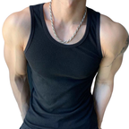 Person wearing a black tank top with visible tattoos on arms and chest.