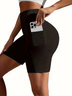 Person wearing black athletic shorts with a phone pocket, holding a phone.