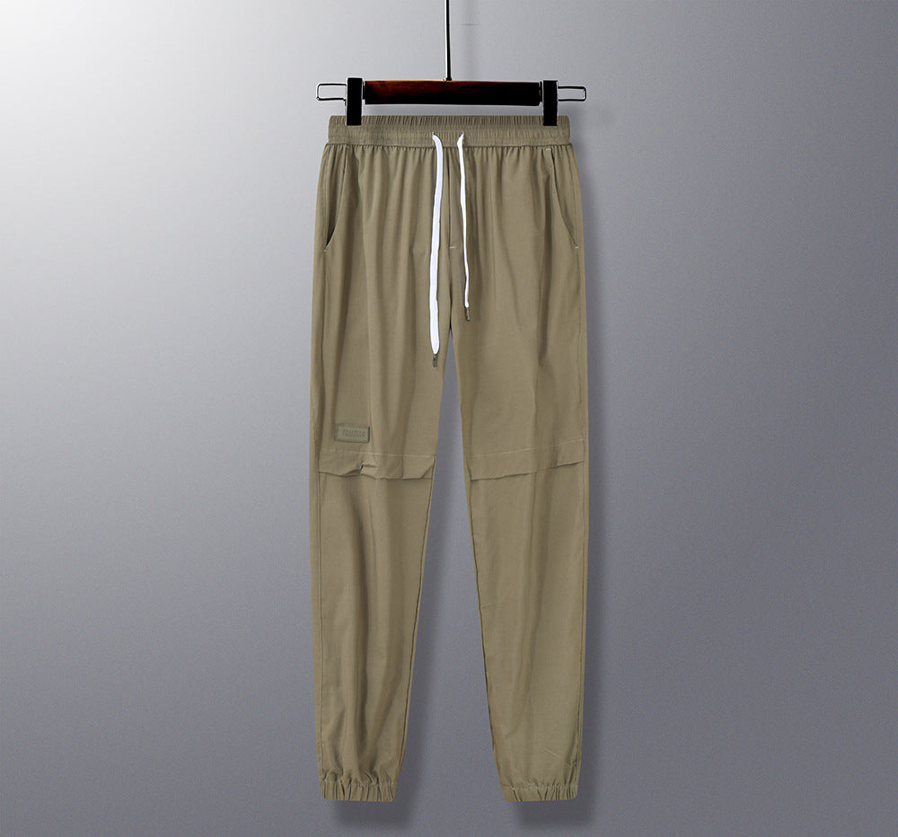 Beige pants on a hanger against a gray background